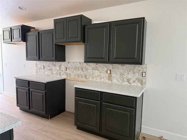 5 Old Glory Ave, Altus, OK 73521 - kitchen featuring backsplash, light countertops, baseboards, and light wood finished floors