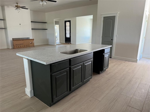 5 Old Glory Ave, Altus, OK 73521 - kitchen featuring ceiling fan, dark cabinetry, a sink, and light wood-type flooring