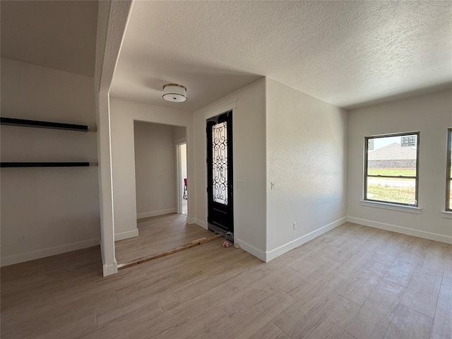 5 Old Glory Ave, Altus, OK 73521 - foyer entrance featuring a textured ceiling, light wood-style floors, and baseboards