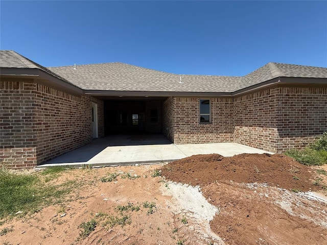 5 Old Glory Ave, Altus, OK 73521 - property entrance featuring brick siding, a shingled roof, and a patio