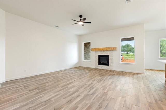 3000 Road Runner Ct, Guthrie, OK 73044 - unfurnished living room with light wood-style floors, ceiling fan, a glass covered fireplace, and baseboards