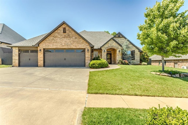 19633 Stratmore Way, Edmond, OK 73012 - view of front facade with an attached garage, driveway, a front yard, a shingled roof, and brick siding