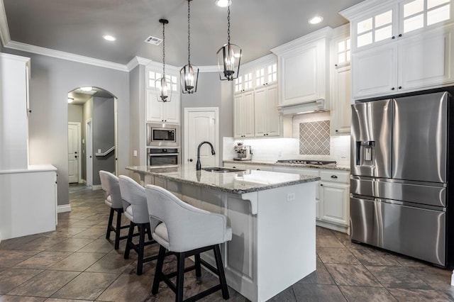 19633 Stratmore Way, Edmond, OK 73012 - kitchen featuring stainless steel appliances, a sink, arched walkways, decorative backsplash, and white cabinets