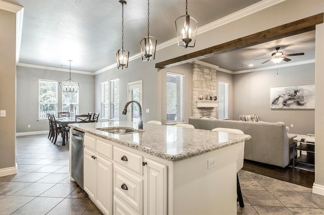 19633 Stratmore Way, Edmond, OK 73012 - kitchen with a sink, open floor plan, a center island with sink, a stone fireplace, and a ceiling fan