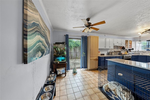 5505 S Villa Ave, Oklahoma City, OK 73119 - kitchen with stainless steel gas stove, a textured ceiling, ceiling fan, white cabinetry, and light tile patterned floors