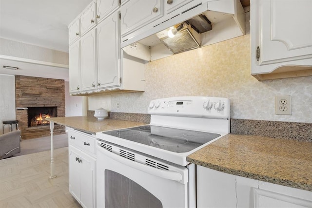 2600 NW 34th St, Oklahoma City, OK 731 - kitchen with white electric stove, under cabinet range hood, and white cabinetry