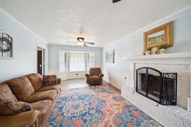 700 Nancy Lynn Ter, Norman, OK 73069 - living area featuring ceiling fan, crown molding, a textured ceiling, wood finished floors, and a wainscoted wall