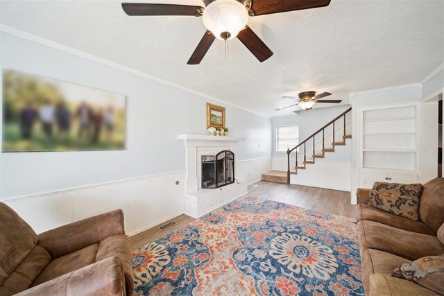 700 Nancy Lynn Ter, Norman, OK 73069 - living area with ceiling fan, wood finished floors, a brick fireplace, stairs, and crown molding