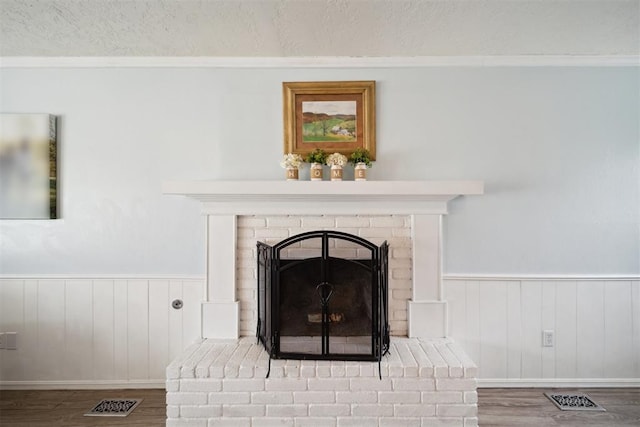 700 Nancy Lynn Ter, Norman, OK 73069 - detailed view of wood finished floors, crown molding, wainscoting, a textured ceiling, and a fireplace