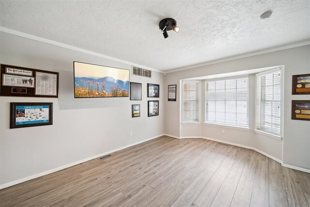 700 Nancy Lynn Ter, Norman, OK 73069 - empty room with a textured ceiling, wood finished floors, crown molding, and baseboards