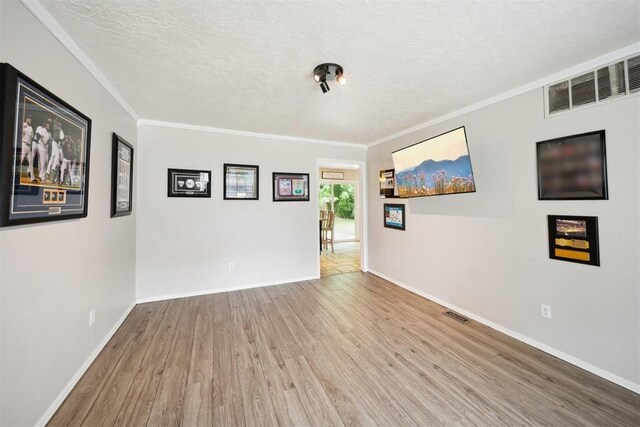 700 Nancy Lynn Ter, Norman, OK 73069 - spare room with wood finished floors, a textured ceiling, baseboards, and crown molding