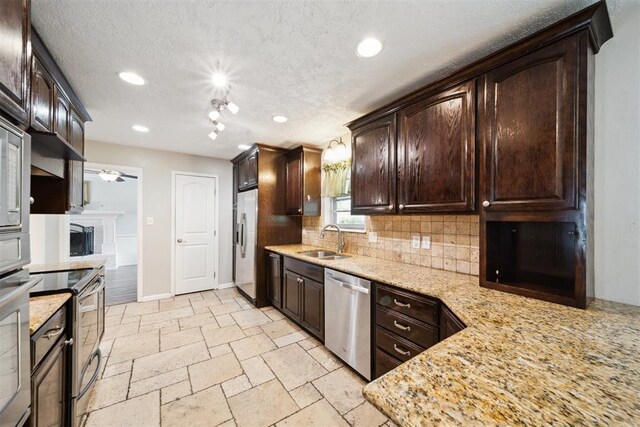 700 Nancy Lynn Ter, Norman, OK 73069 - kitchen with stainless steel appliances, a sink, backsplash, dark brown cabinets, and recessed lighting
