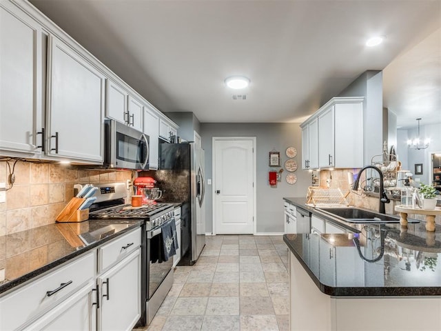 419 NE 23rd Ter, Newcastle, OK 73065 - kitchen with appliances with stainless steel finishes, a sink, decorative backsplash, baseboards, and dark stone counters