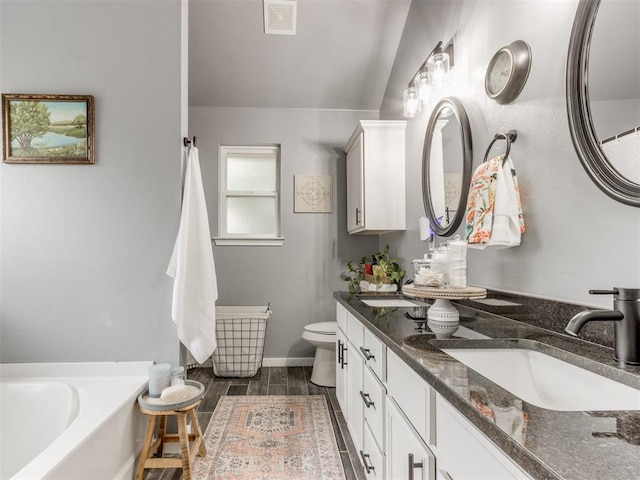 419 NE 23rd Ter, Newcastle, OK 73065 - full bath with a garden tub, toilet, double vanity, wood finished floors, and baseboards