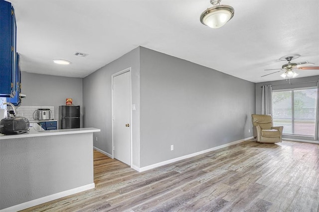1904 Gemini St, Altus, OK 73521 - kitchen featuring blue cabinets, freestanding refrigerator, light wood-type flooring, light countertops, and a ceiling fan