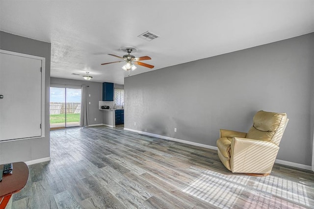 1904 Gemini St, Altus, OK 73521 - unfurnished living room with a ceiling fan, baseboards, and wood finished floors