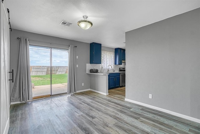 1904 Gemini St, Altus, OK 73521 - kitchen with blue cabinetry, light countertops, light wood-style flooring, baseboards, and stove