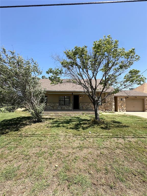 1024 Zinn Ave, Blair, OK 73526 - view of front of property with stone siding, an attached garage, a front lawn, and driveway