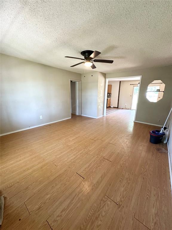 1024 Zinn Ave, Blair, OK 73526 - spare room featuring a textured ceiling, ceiling fan, light wood finished floors, and baseboards