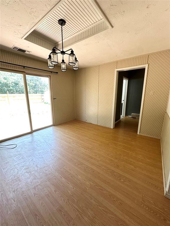 1024 Zinn Ave, Blair, OK 73526 - spare room featuring wood finished floors, a chandelier, and a textured ceiling