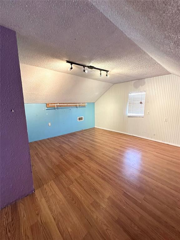 1024 Zinn Ave, Blair, OK 73526 - additional living space featuring wood finished floors, lofted ceiling, and a textured ceiling