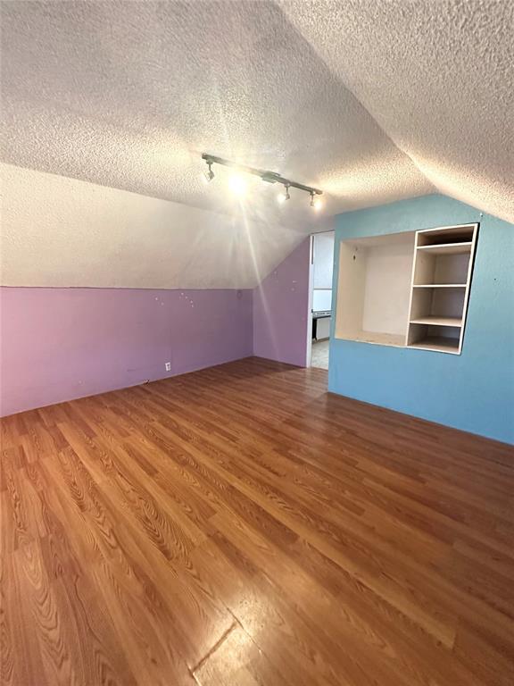 1024 Zinn Ave, Blair, OK 73526 - bonus room with vaulted ceiling, a textured ceiling, and wood finished floors
