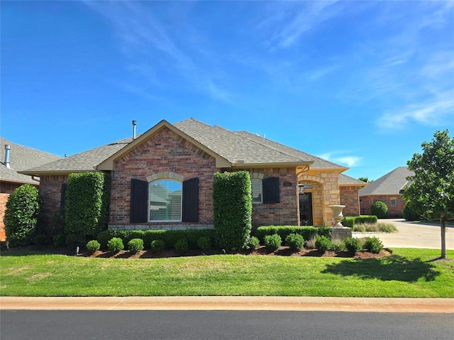 5608 NW 127th St, Oklahoma City, OK 73142 - view of front of home with brick siding, roof with shingles, and a front yard