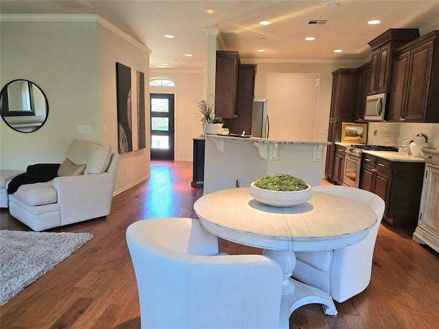 5608 NW 127th St, Oklahoma City, OK 73142 - dining area featuring dark wood-type flooring, ornamental molding, and recessed lighting