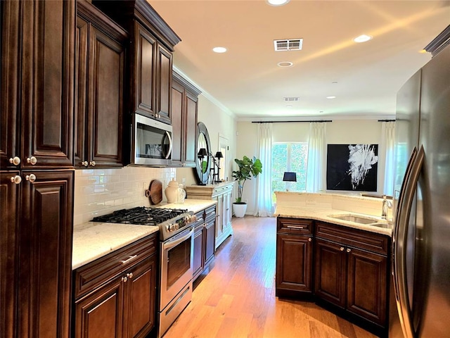 5608 NW 127th St, Oklahoma City, OK 73142 - kitchen with appliances with stainless steel finishes, a sink, decorative backsplash, light stone counters, and recessed lighting