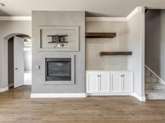 832 Gateway Bridge Rd, Edmond, OK 73034 - unfurnished living room with crown molding, arched walkways, wood finished floors, baseboards, and a fireplace