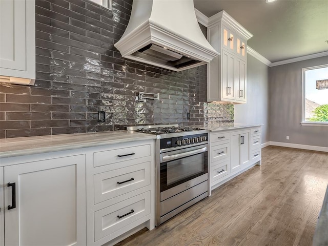 832 Gateway Bridge Rd, Edmond, OK 73034 - kitchen featuring stainless steel range with gas stovetop, custom exhaust hood, light countertops, backsplash, and crown molding