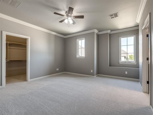 832 Gateway Bridge Rd, Edmond, OK 73034 - unfurnished bedroom with multiple windows, crown molding, carpet floors, baseboards, and a walk in closet