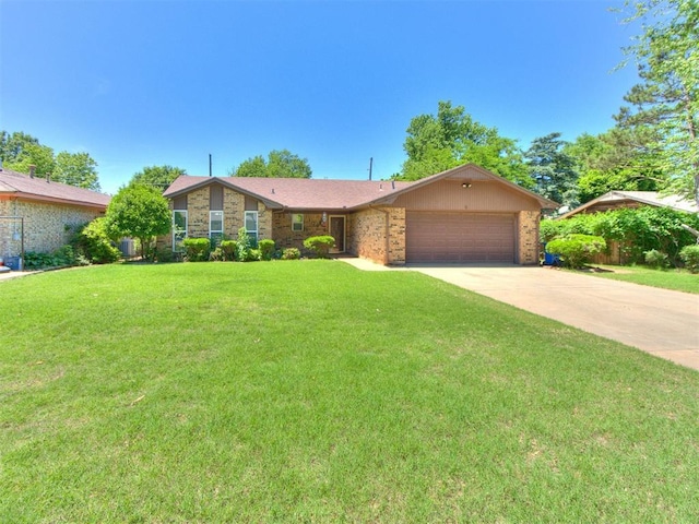 view of front of home with a garage, a front lawn, driveway, and brick siding