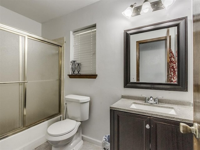 full bathroom featuring toilet, baseboards, vanity, and enclosed tub / shower combo