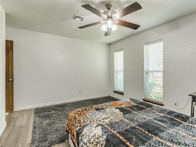 bedroom with wood finished floors, baseboards, and a ceiling fan