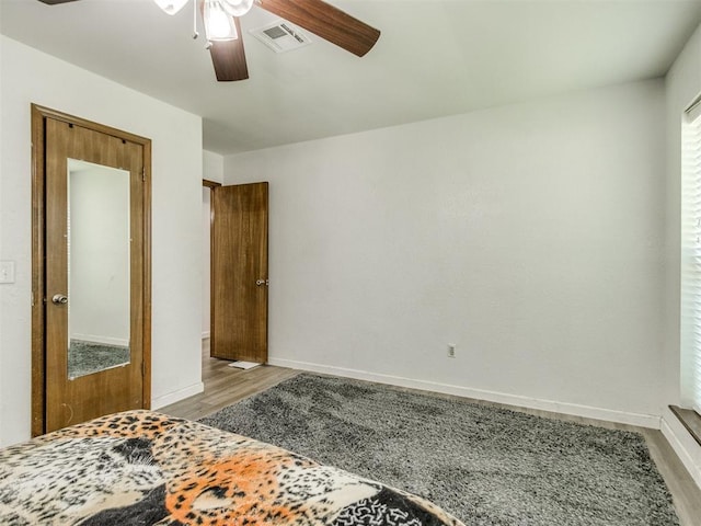 unfurnished bedroom featuring wood finished floors, baseboards, and ceiling fan