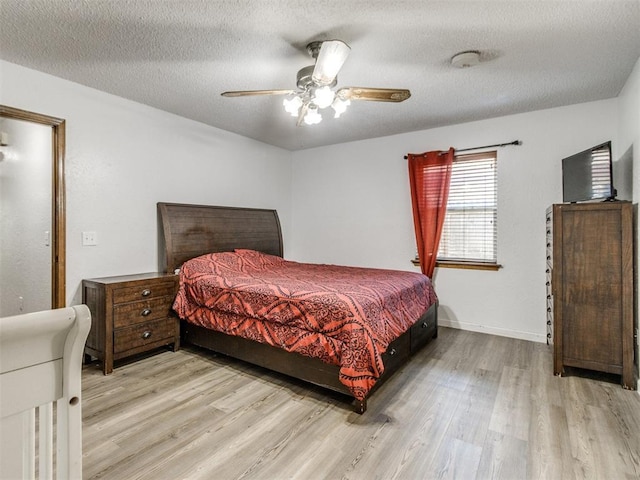 bedroom with wood finished floors, ceiling fan, a textured ceiling, and baseboards