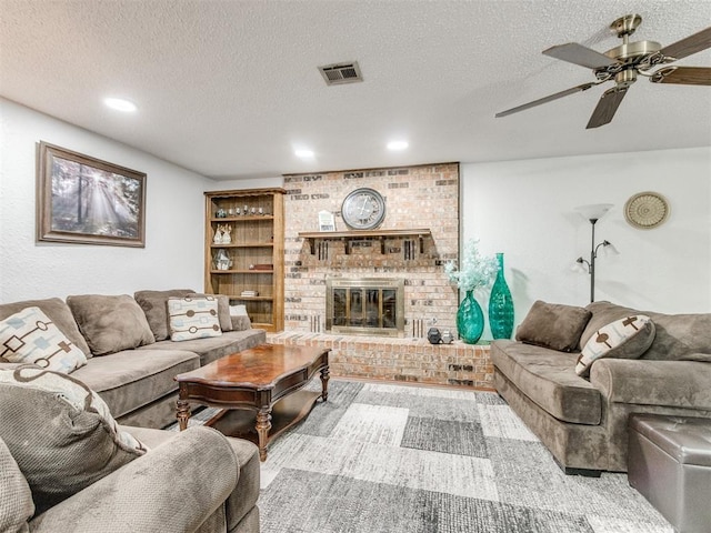 living area featuring a textured ceiling, a brick fireplace, a ceiling fan, recessed lighting, and built in features