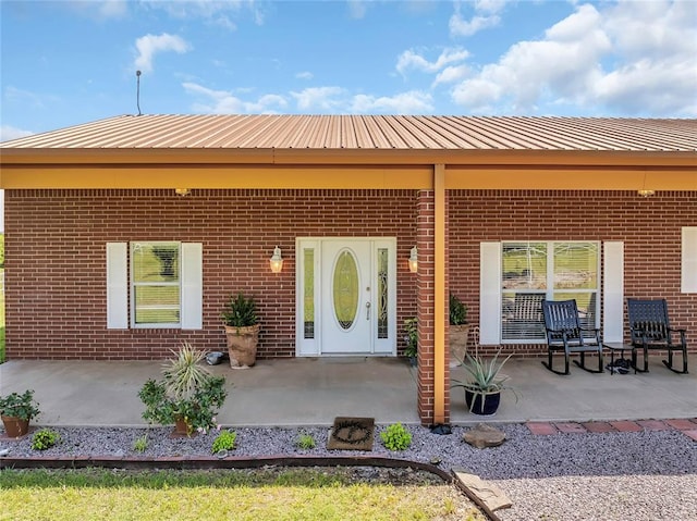 28256 N County Road 3210th Rd, Wynnewood, OK 73098 - property entrance with brick siding, metal roof, and a patio area