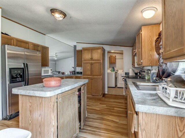 11550 Timber Trl, Lexington, OK 73051 - kitchen featuring stainless steel fridge with ice dispenser, white microwave, washing machine and clothes dryer, light wood finished floors, and light countertops