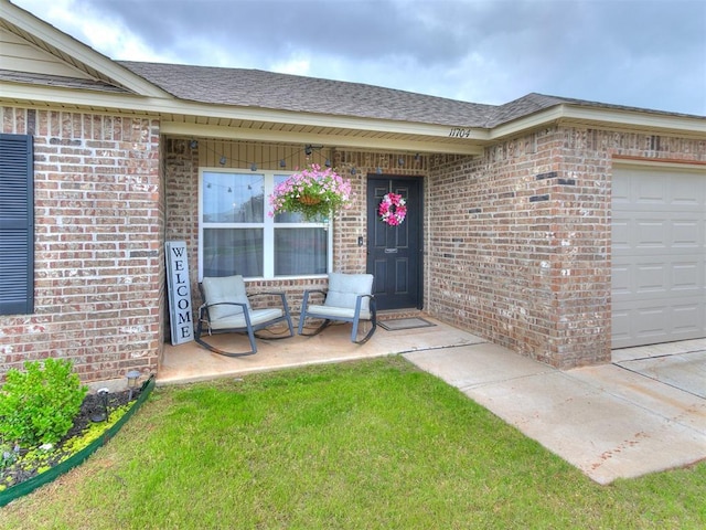 11704 NW 99th Ter, Yukon, OK 73099 - entrance to property with brick siding, a garage, a porch, a shingled roof, and a lawn