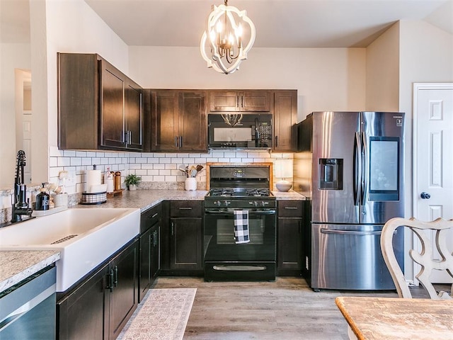 11704 NW 99th Ter, Yukon, OK 73099 - kitchen featuring black appliances, a chandelier, light wood-type flooring, tasteful backsplash, and light countertops