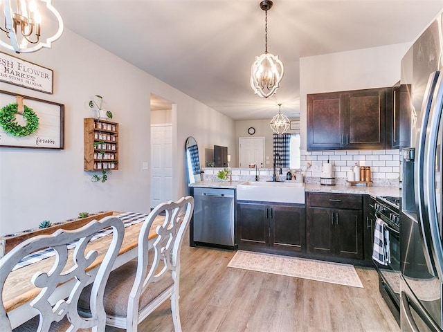 11704 NW 99th Ter, Yukon, OK 73099 - kitchen featuring appliances with stainless steel finishes, a chandelier, a sink, and light wood finished floors
