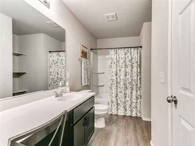 11704 NW 99th Ter, Yukon, OK 73099 - full bathroom featuring wood finished floors, toilet, vanity, and shower / bathtub combination with curtain