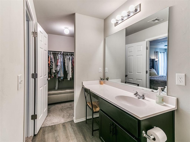 11704 NW 99th Ter, Yukon, OK 73099 - bathroom featuring wood finished floors, vanity, ensuite bathroom, and baseboards