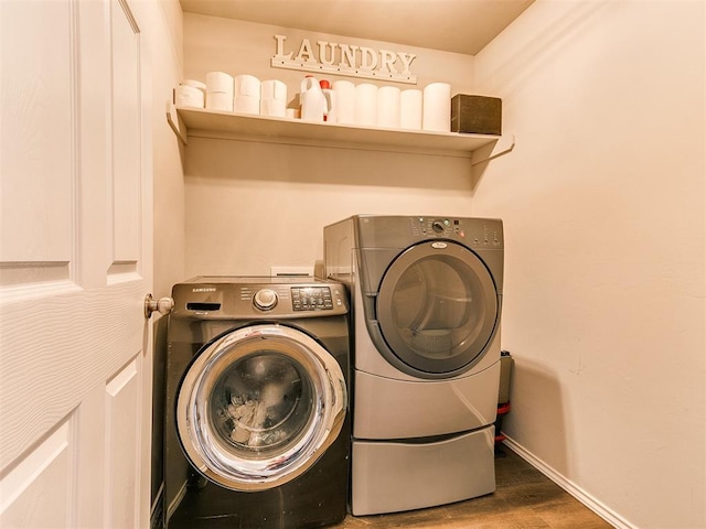 11704 NW 99th Ter, Yukon, OK 73099 - washroom featuring washing machine and clothes dryer, baseboards, and wood finished floors