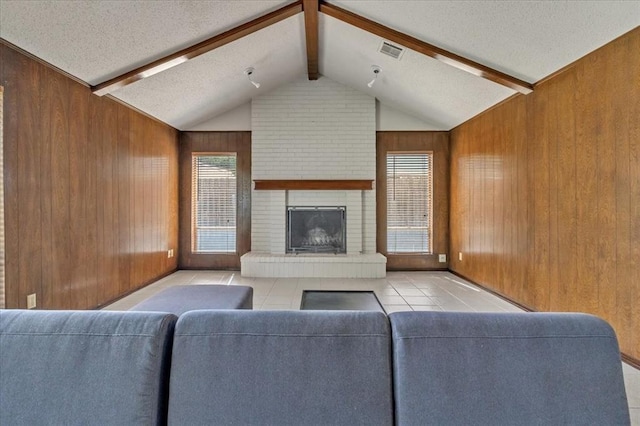 708 Cross Timbers Dr, Moore, OK 73160 - tiled living area featuring wood walls, a textured ceiling, and a fireplace