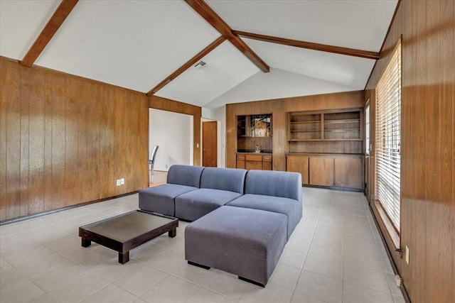 708 Cross Timbers Dr, Moore, OK 73160 - living room featuring wood walls, beam ceiling, light tile patterned floors, built in shelves, and high vaulted ceiling