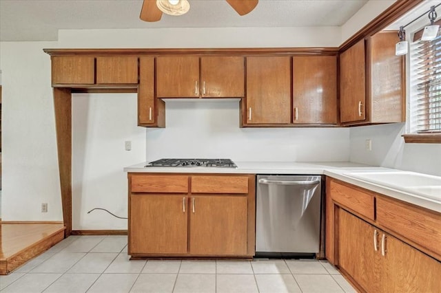 708 Cross Timbers Dr, Moore, OK 73160 - kitchen with stainless steel appliances, brown cabinets, a ceiling fan, light countertops, and light tile patterned floors