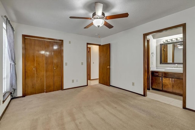 708 Cross Timbers Dr, Moore, OK 73160 - unfurnished bedroom with a sink, light colored carpet, baseboards, a ceiling fan, and ensuite bath